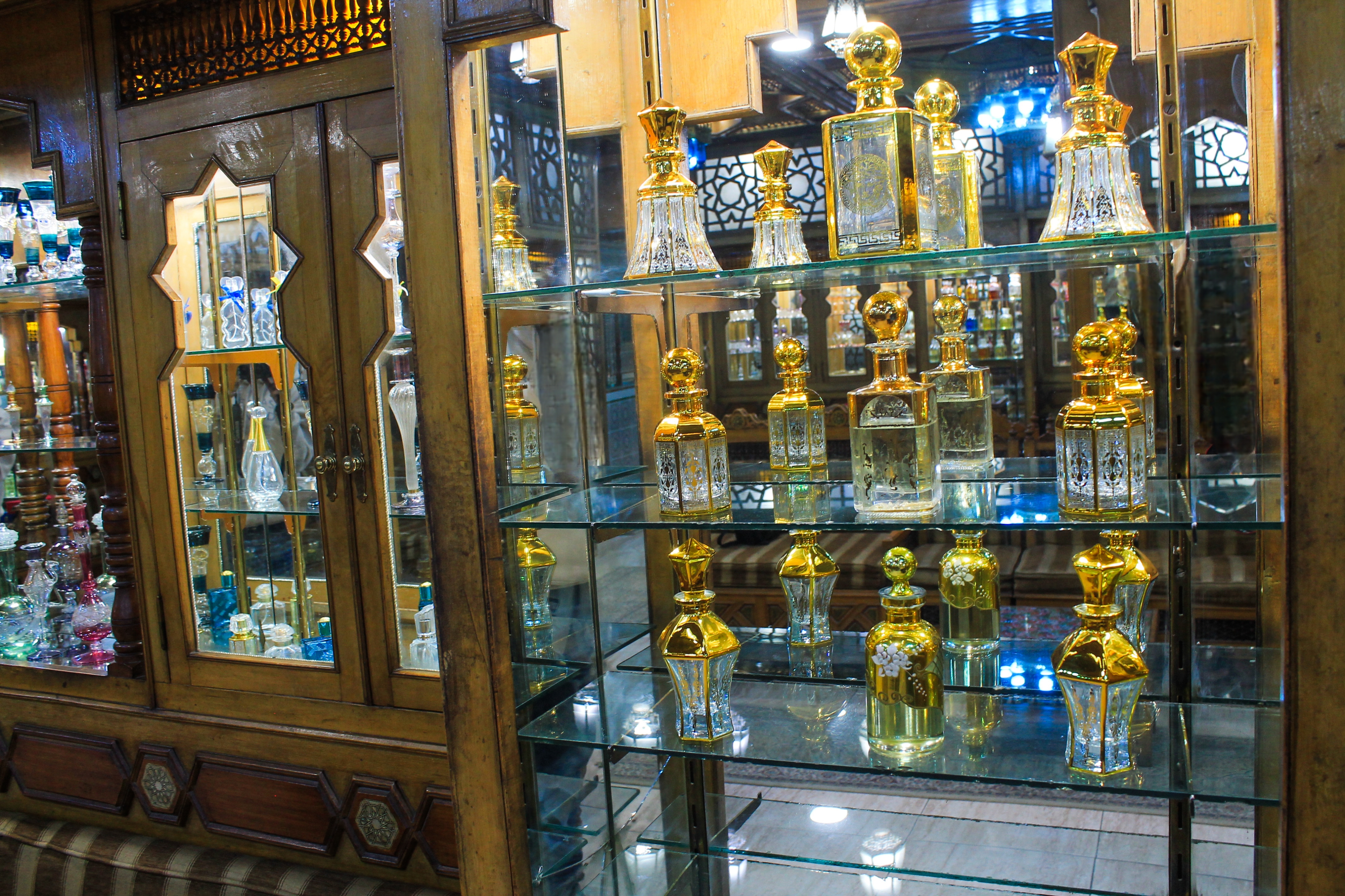 Hand-blown golden-capped glass vessels arranged in our traditional illuminated wooden display cases.