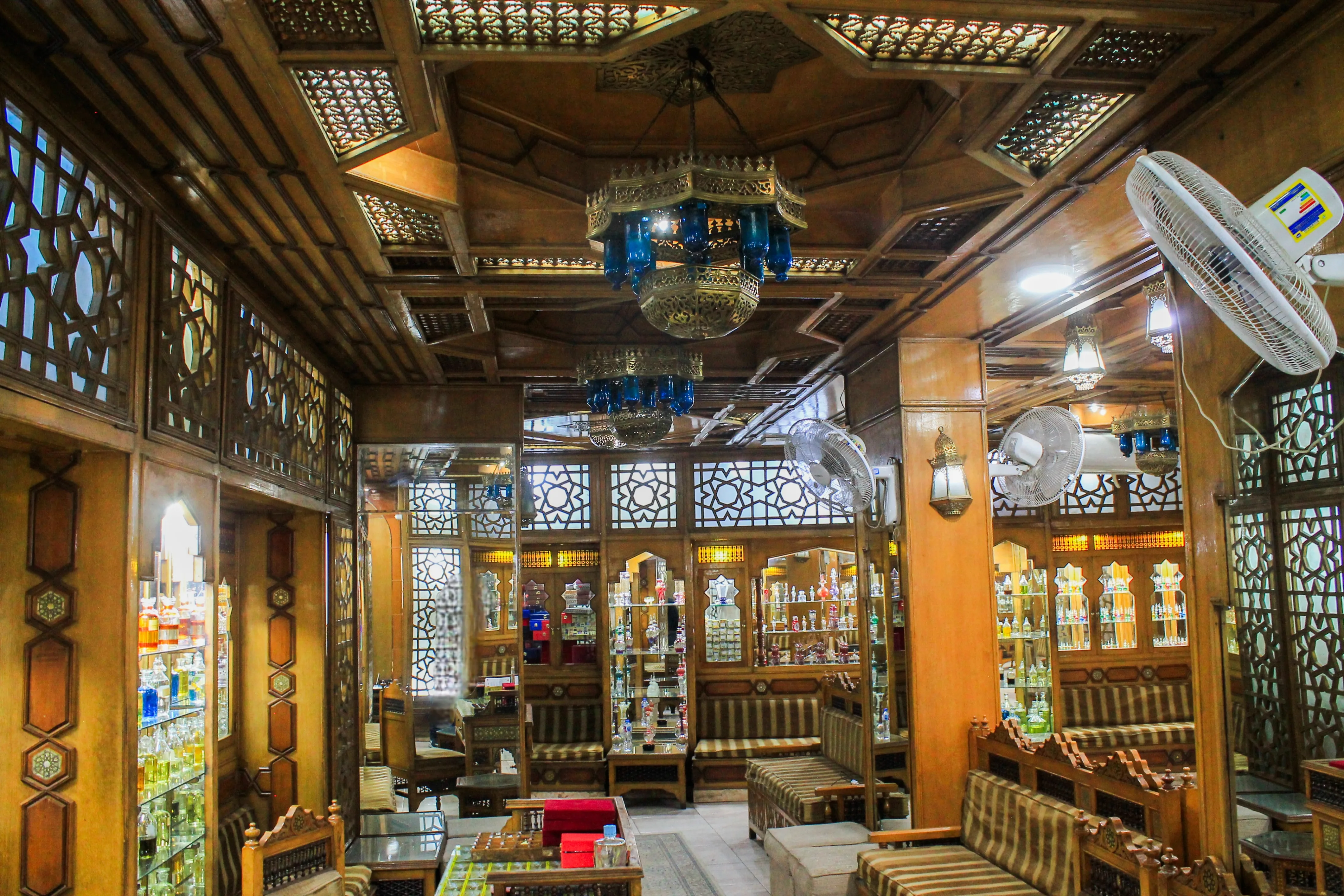The grand hand-carved wooden ceiling and palatial blue chandeliers that define the historic ambiance of our shop.