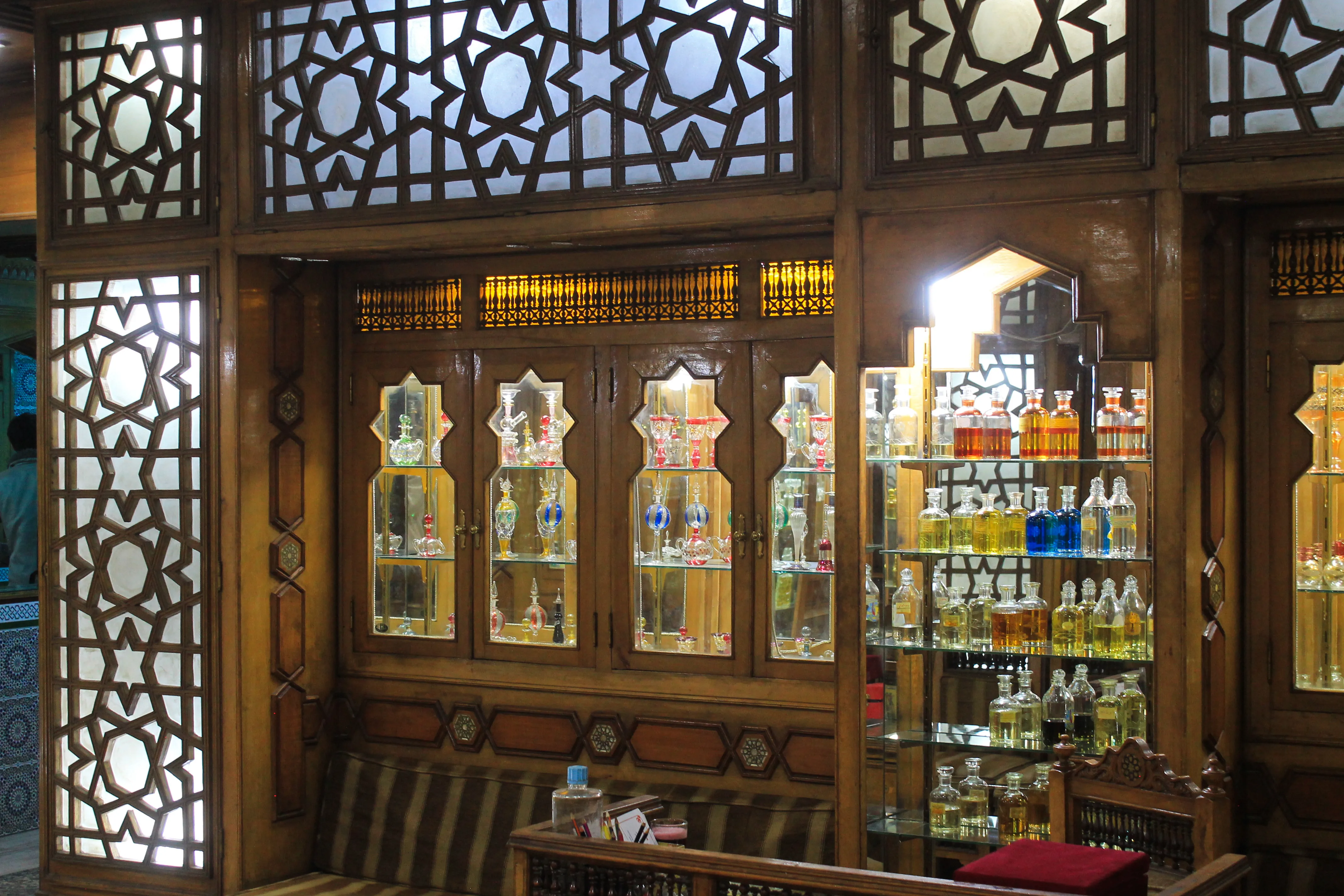 A detailed perspective of the hand-carved Mashrabiya woodwork integrated into our fragrance display walls.