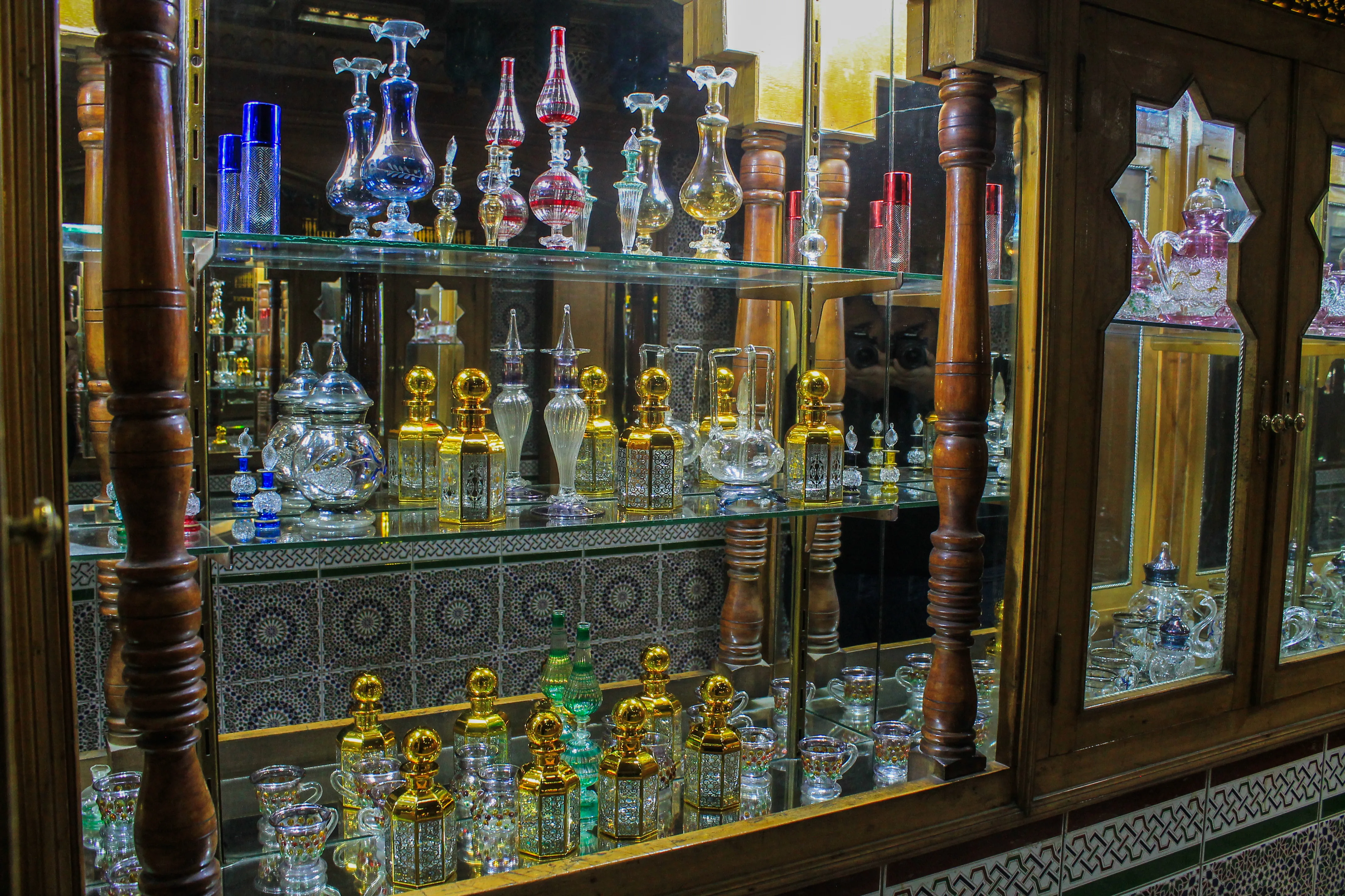 Ornate illuminated shelving displaying our full range of master-blended fragrances and decorative glass.