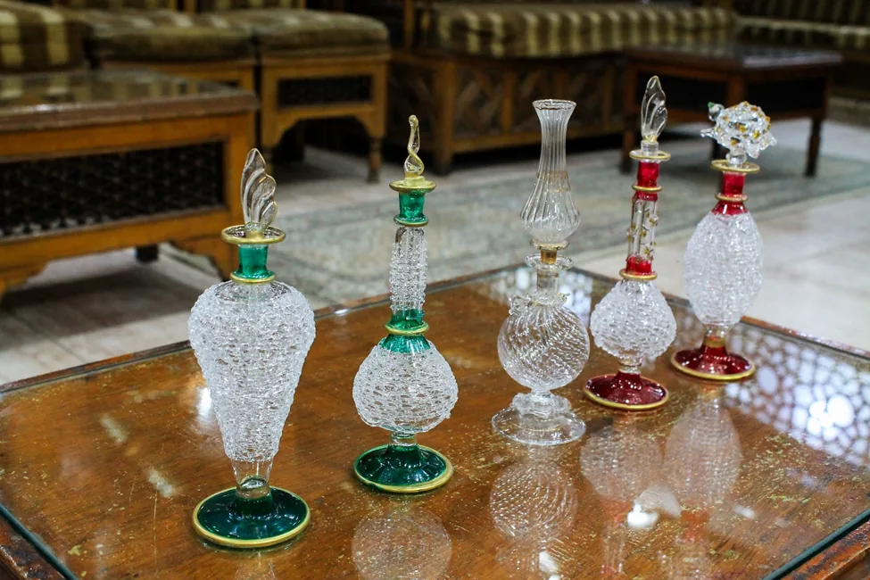 Distinctive bubble-textured and ruby-accented glass bottles, each a unique work of art handcrafted in Giza.